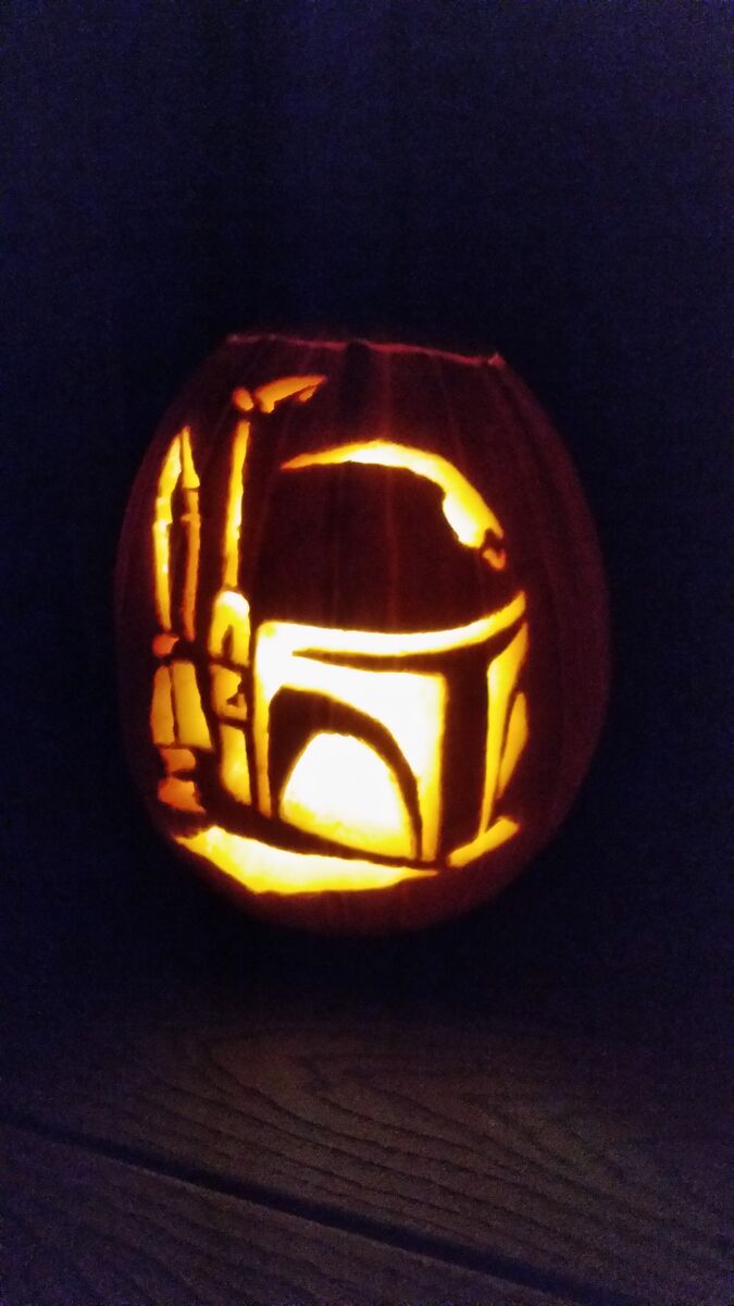 A pumpkin carved with Boba Fett from Star Wars.