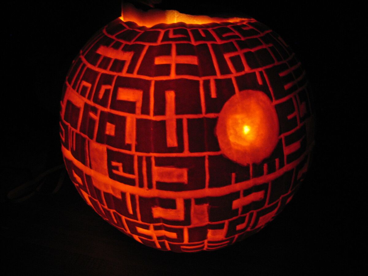 A pumpkin carved with the Death Star from Star Wars.