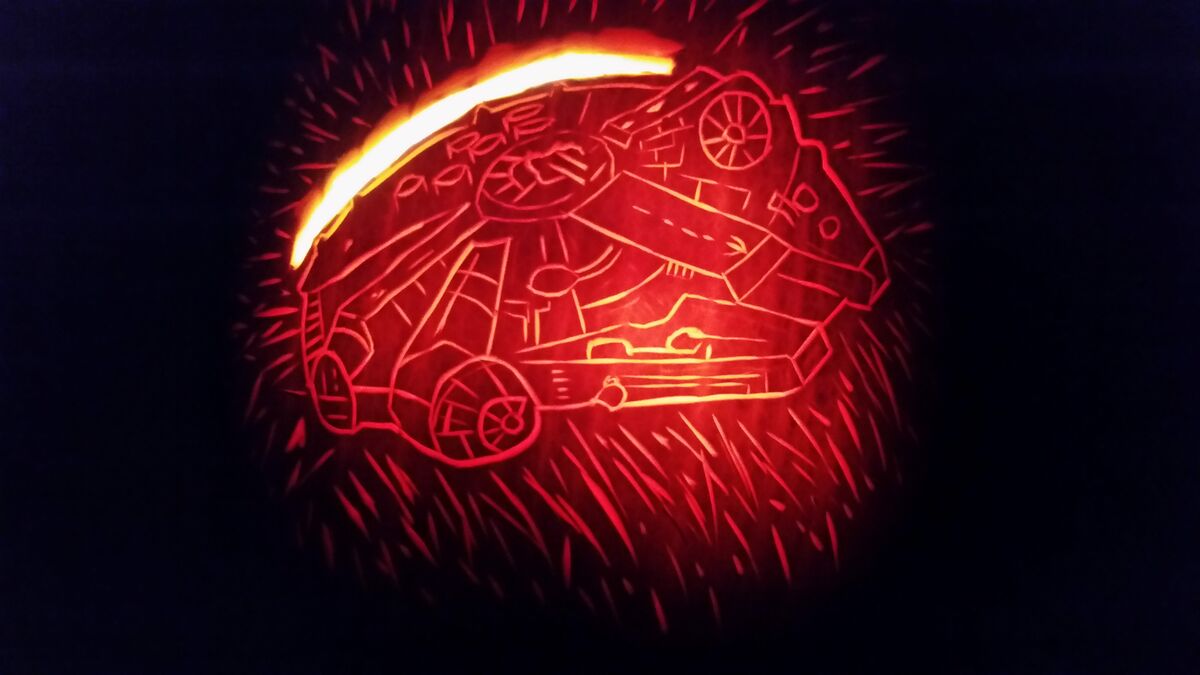 A pumpkin carved with the Millennium Falcon from Star Wars.