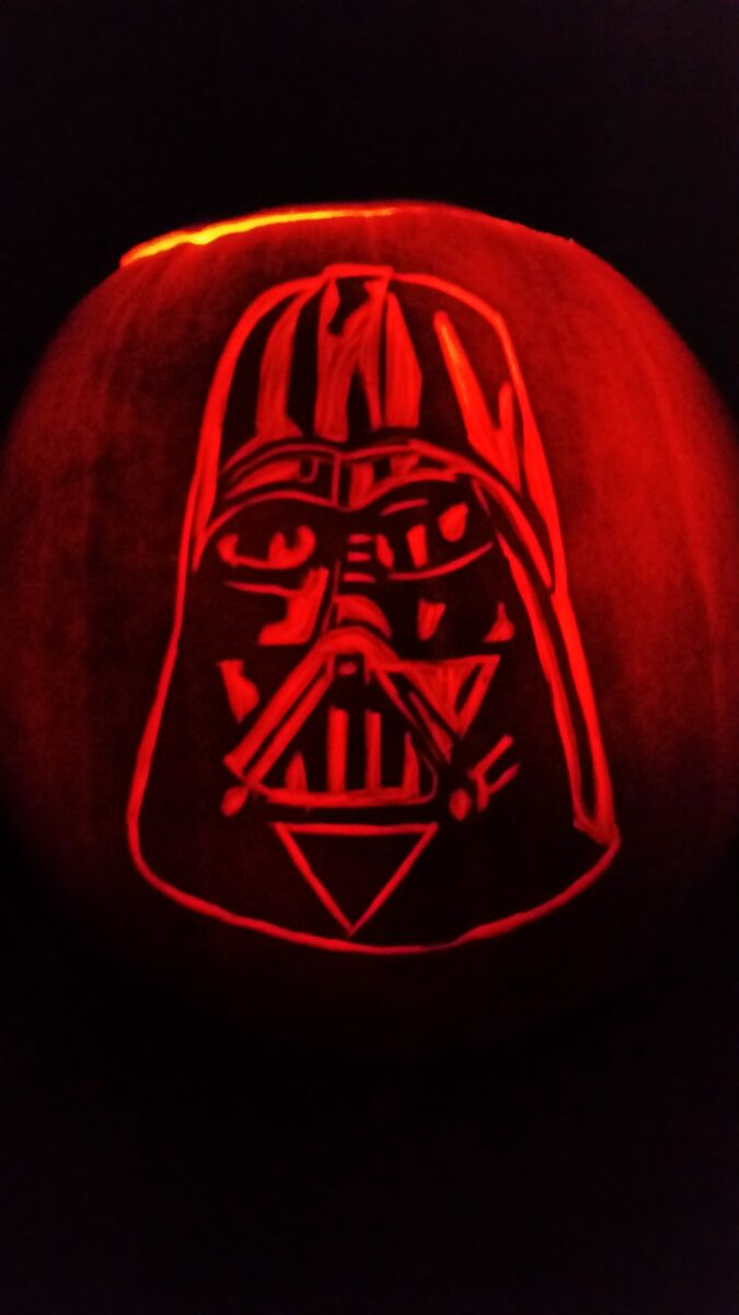 A pumpkin carved with Darth Vader from Star Wars.