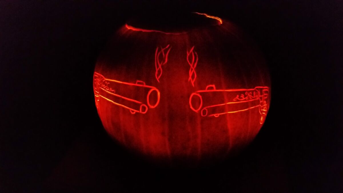 A pumpkin carved with a pair of revolvers.