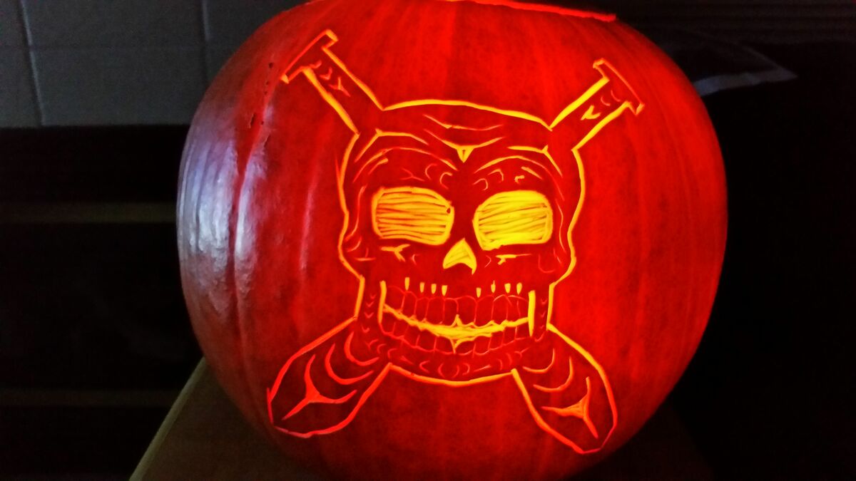 A pumpkin carved with a skull and crossed oars.