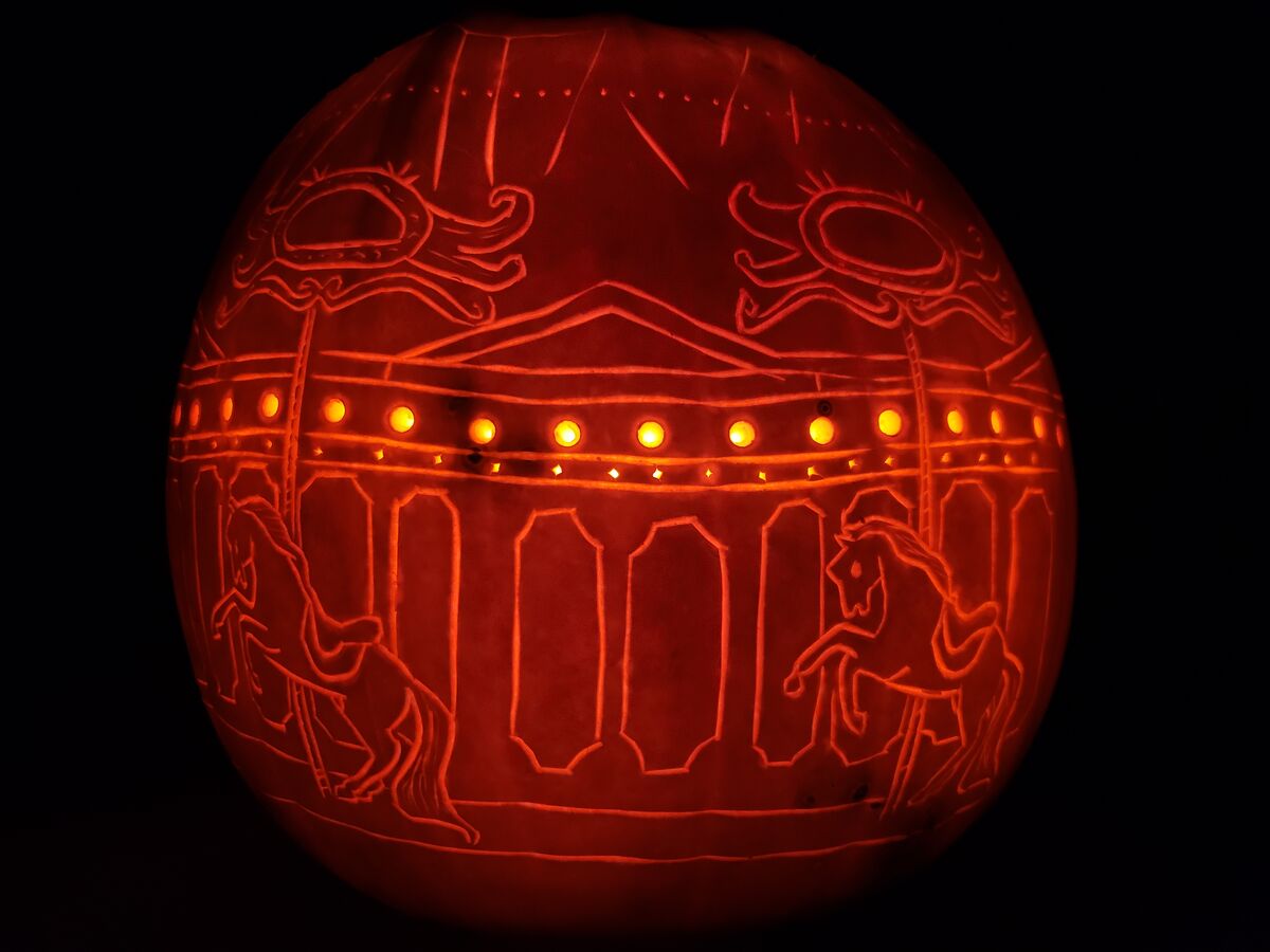 A pumpkin carved with a carousel.