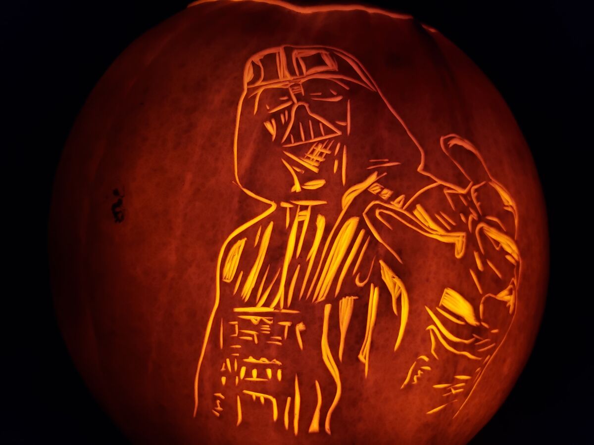 A pumpkin carved with Darth Vader from Star Wars.