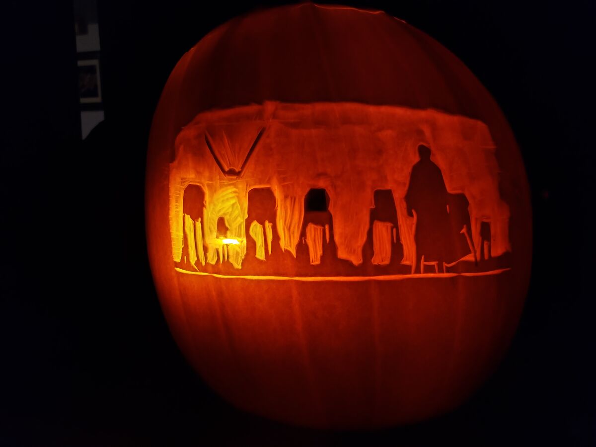 A pumpkin carved with Luke Skywalker against the New Order, from Star Wars.