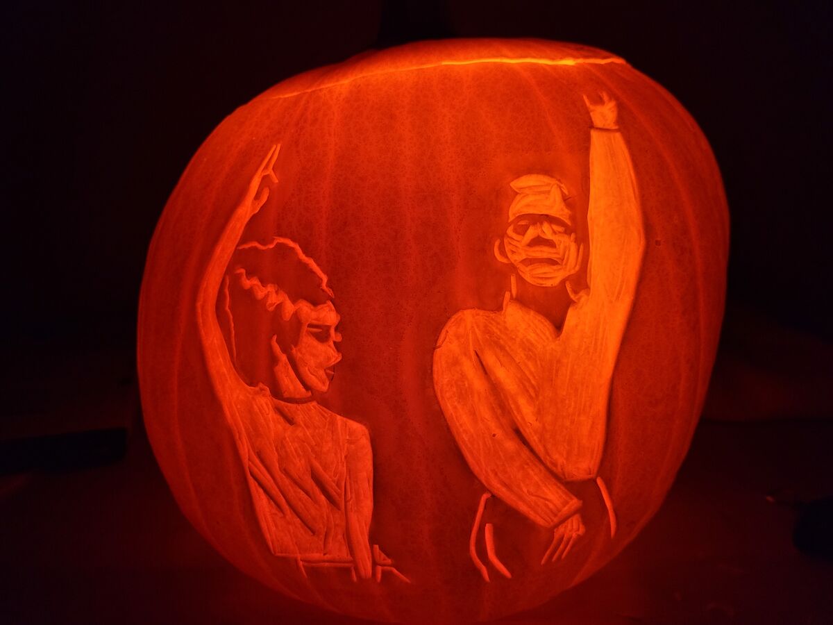 A pumpkin carved with Frankenstein and Bride doing the monster mash.