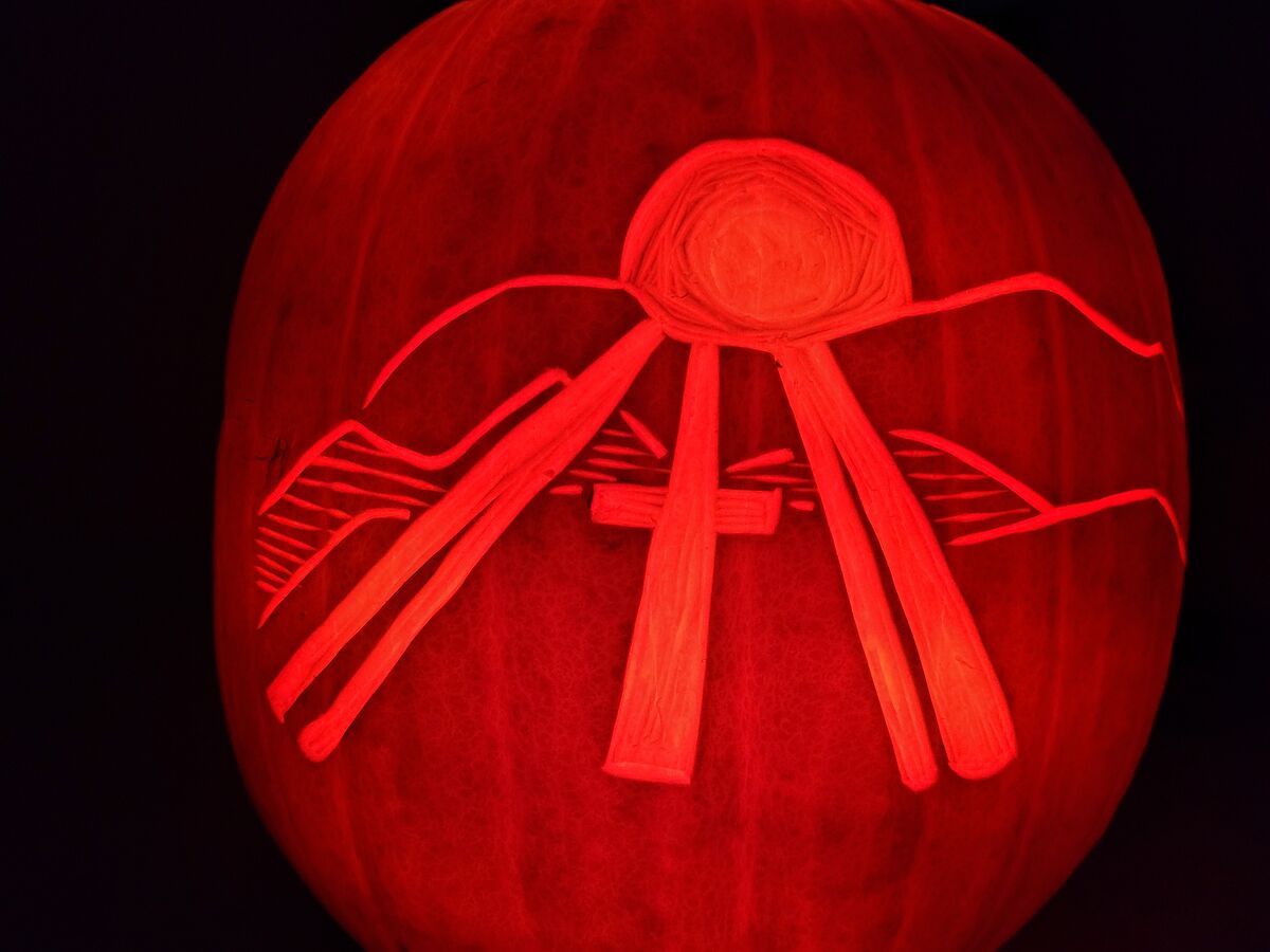 A pumpkin carved with the New Hope Church logo.