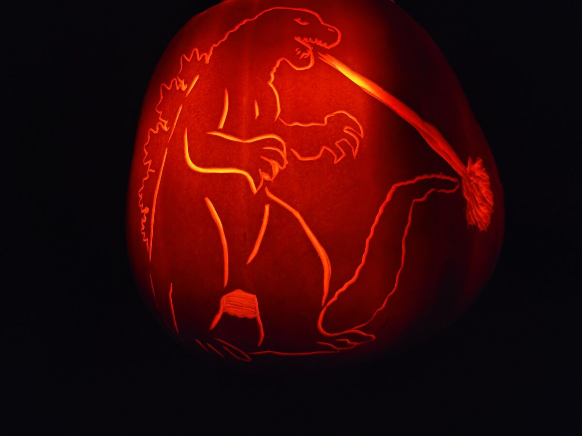 A pumpkin carved with Godzilla.